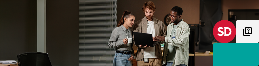 Standing togther and looking into the computer screen talking about how to Unlock Your IT Career with A+ Certification