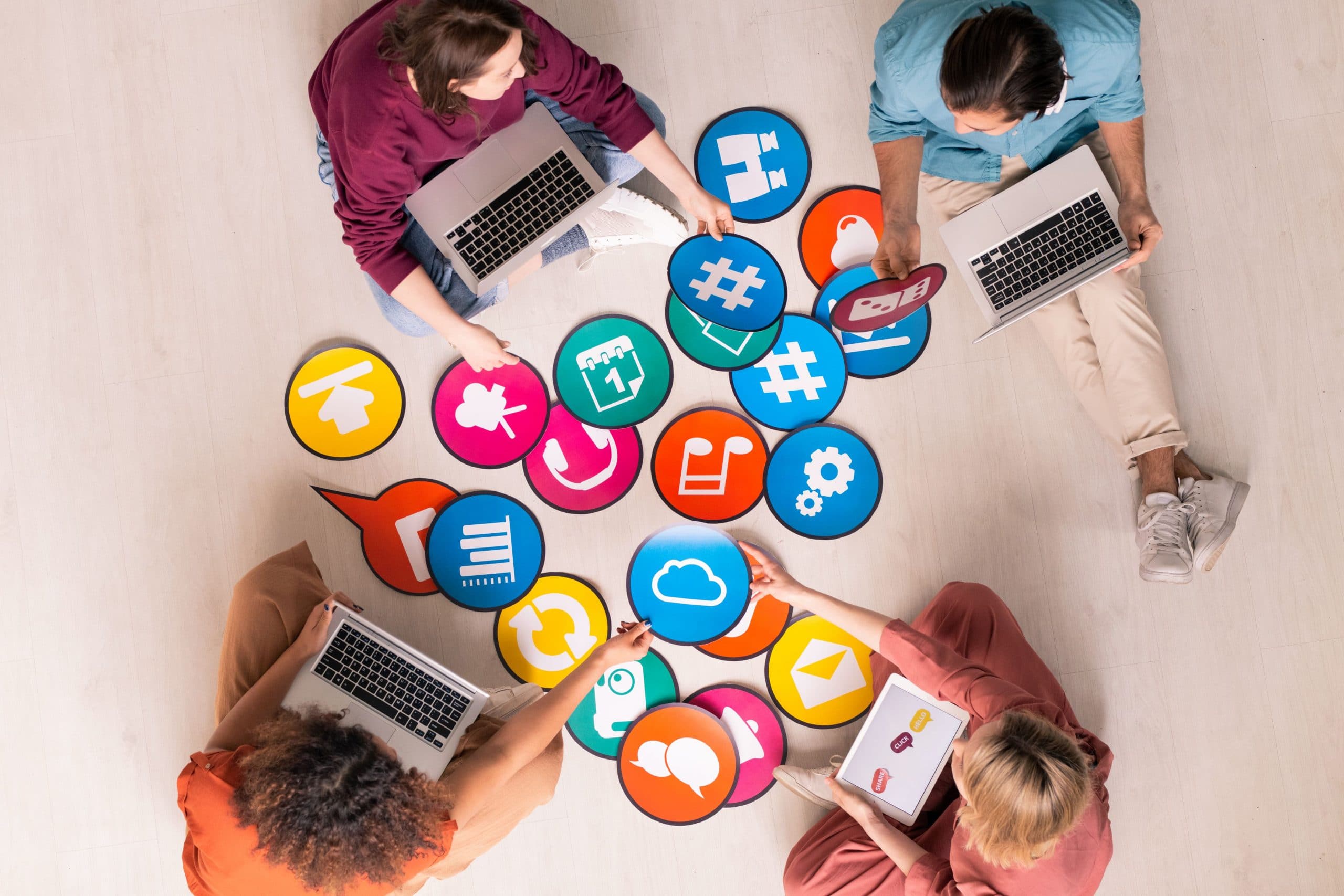 team of people using laptops surrounded by icons refer to internet marketing tools