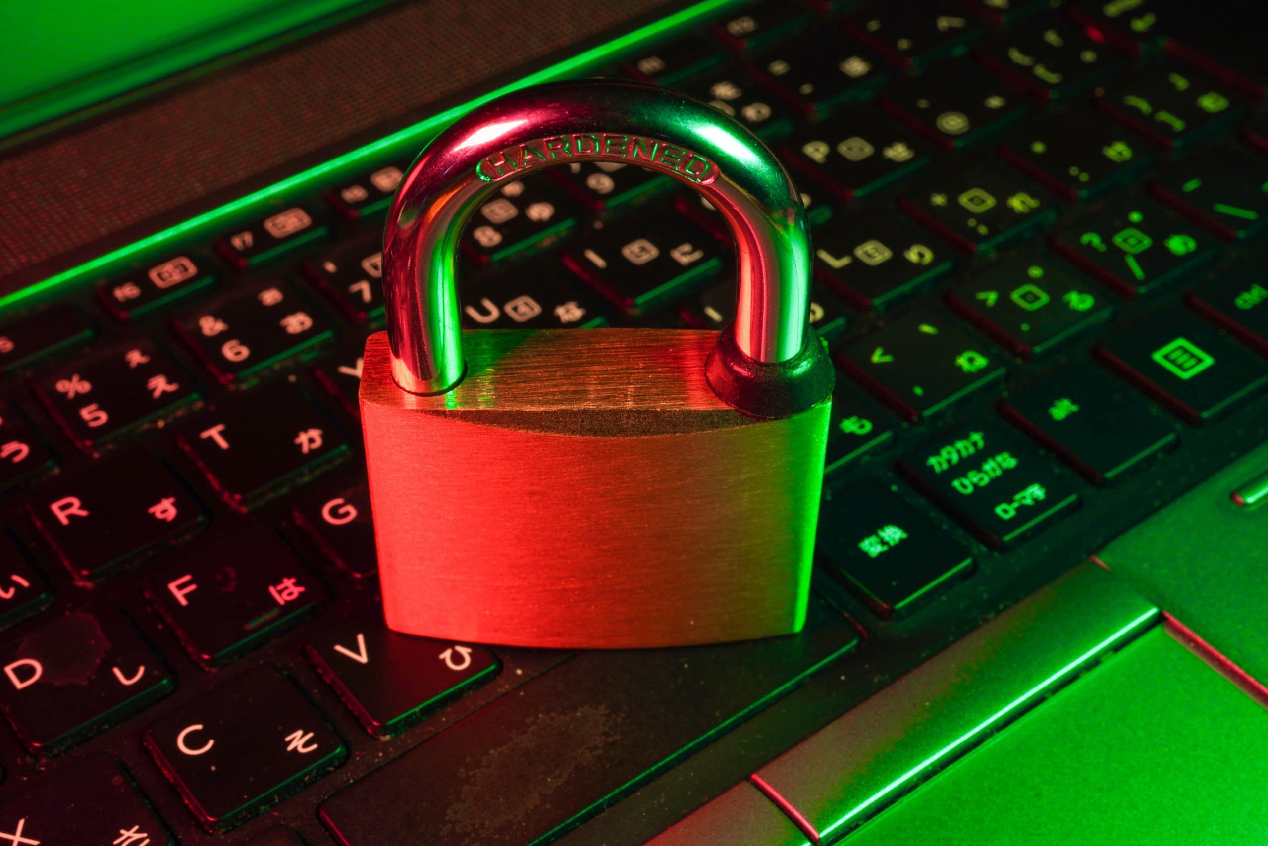 locked padlock ontop of a keyboard with red and green lighting
