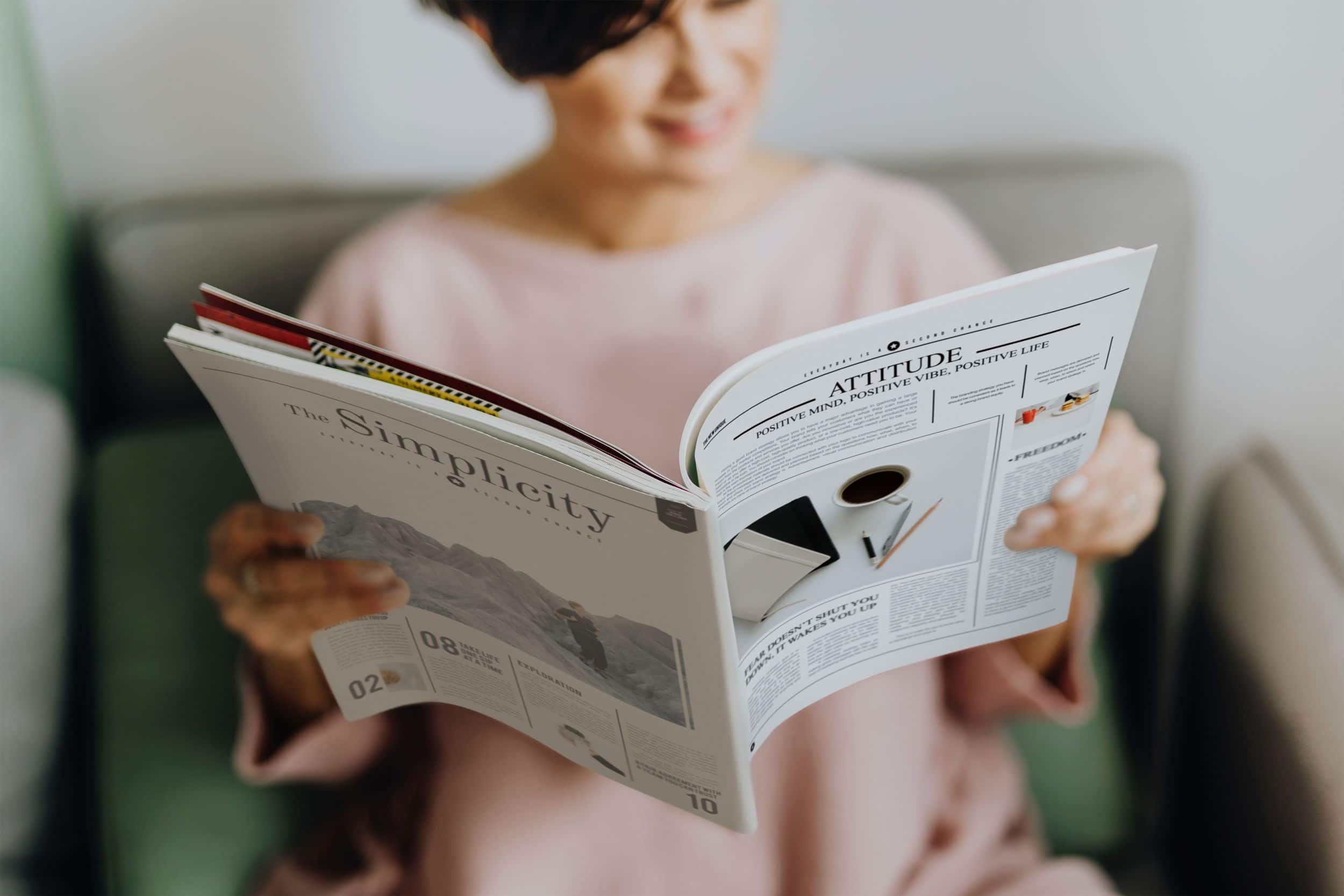 women reading a newspaper style magazine